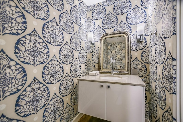 bathroom with vanity and wallpapered walls