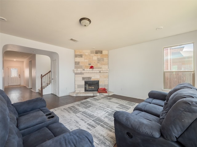 670 Landon Samuel Loop, Pflugerville, TX 78660 - living area with arched walkways, healthy amount of natural light, stairs, and a stone fireplace