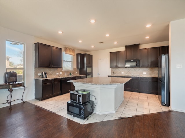670 Landon Samuel Loop, Pflugerville, TX 78660 - kitchen featuring black appliances, a center island, backsplash, dark brown cabinets, and recessed lighting