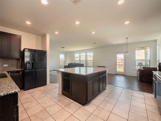 670 Landon Samuel Loop, Pflugerville, TX 78660 - kitchen with black fridge with ice dispenser, open floor plan, recessed lighting, light tile patterned flooring, and a kitchen island