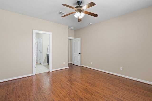 4706 Madrid Dr, Georgetown, TX 78628 - unfurnished bedroom featuring wood finished floors, baseboards, a ceiling fan, and ensuite bath