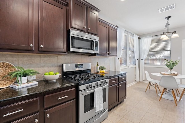 4706 Madrid Dr, Georgetown, TX 78628 - kitchen featuring stainless steel appliances, dark brown cabinetry, backsplash, dark stone countertops, and baseboards
