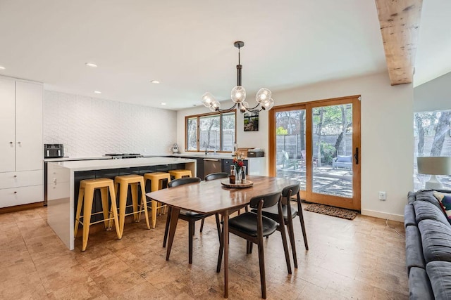 dining space with a wealth of natural light, a notable chandelier, recessed lighting, and baseboards