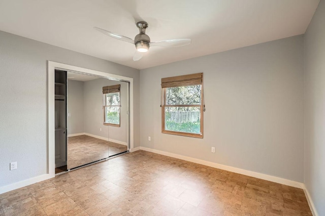 unfurnished bedroom with a closet, ceiling fan, and baseboards