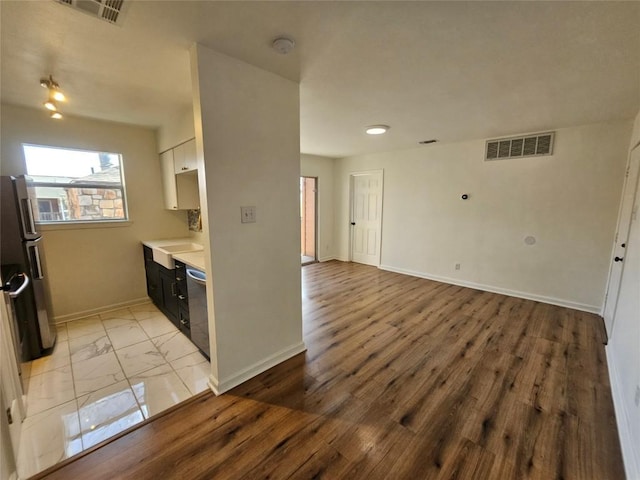 6903 Deatonhill Dr Unit 2, Austin, TX 78745 - kitchen featuring light countertops, stainless steel dishwasher, freestanding refrigerator, open floor plan, and light wood finished floors