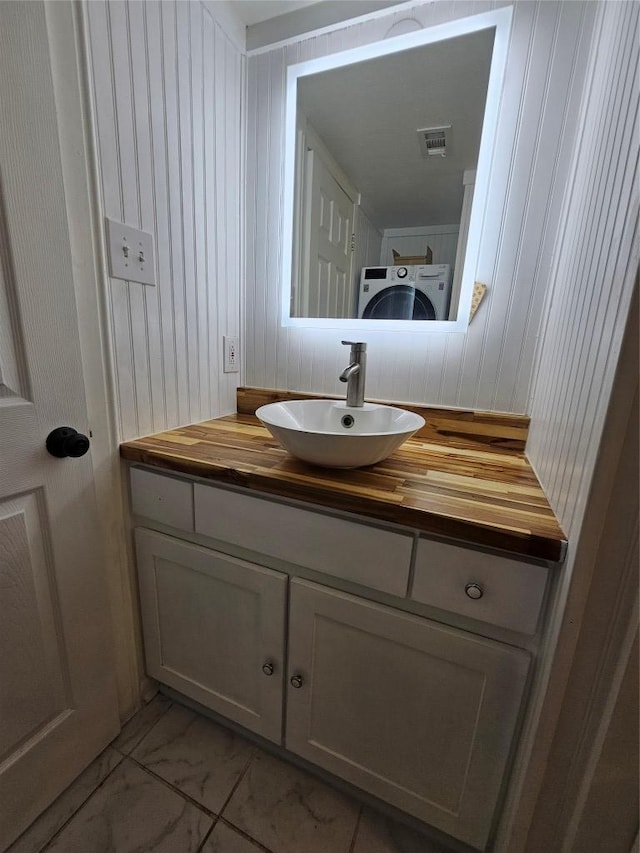 6903 Deatonhill Dr Unit 2, Austin, TX 78745 - bathroom with marble finish floors, vanity, washer / clothes dryer, and wood walls