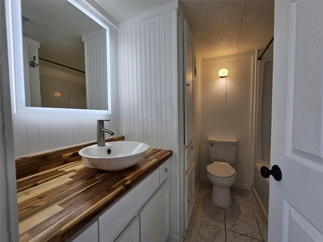 6903 Deatonhill Dr Unit 2, Austin, TX 78745 - bathroom featuring marble finish floors, vanity, wood walls, a shower, and a textured ceiling