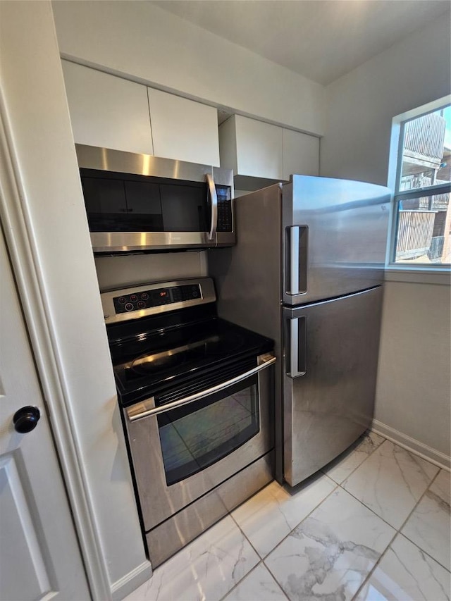 6903 Deatonhill Dr Unit 2, Austin, TX 78745 - kitchen with stainless steel appliances, light marble finish flooring, and white cabinetry