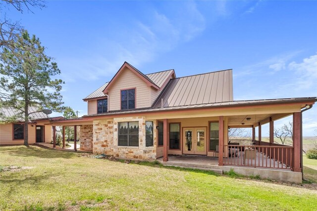 149 Colovista Dr, Bastrop, TX 78602 - rear view of property featuring a lawn, a standing seam roof, and a metal roof