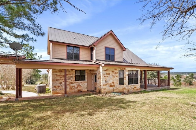 149 Colovista Dr, Bastrop, TX 78602 - rear view of house featuring a lawn, a metal roof, stone siding, and a patio area