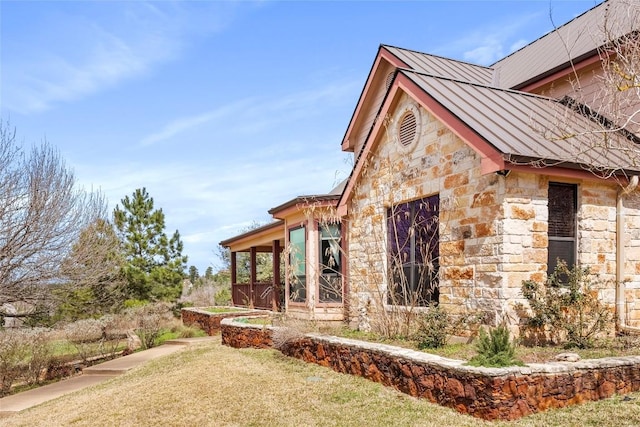 149 Colovista Dr, Bastrop, TX 78602 - view of home's exterior featuring a standing seam roof, stone siding, a metal roof, and a lawn