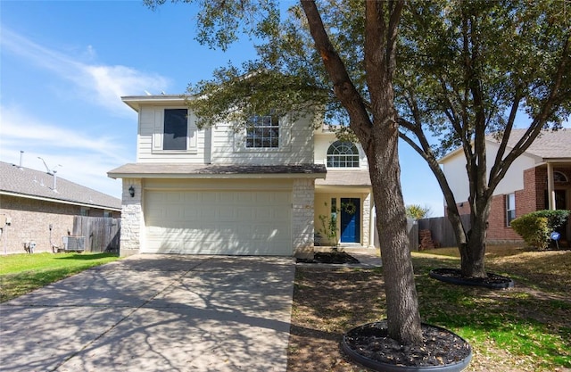 traditional-style house featuring central air condition unit, an attached garage, concrete driveway, and fence