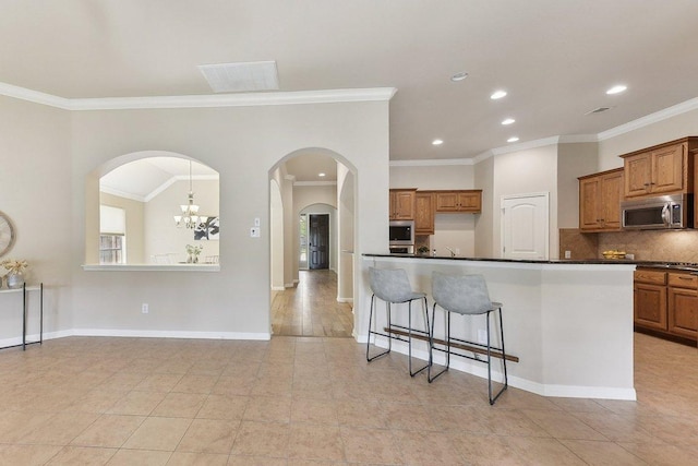 2812 Prosperity, Leander, TX 78641 - kitchen with stainless steel microwave, brown cabinetry, dark countertops, crown molding, and recessed lighting