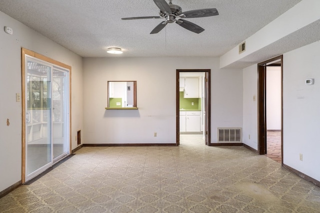 spare room with visible vents, baseboards, and a textured ceiling