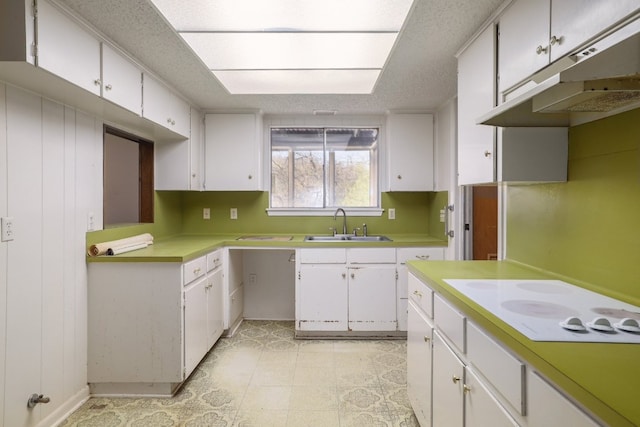 kitchen featuring white cabinetry, white electric stovetop, under cabinet range hood, and a sink