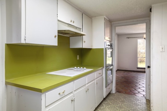 kitchen featuring under cabinet range hood, white cabinets, white electric stovetop, and a textured ceiling