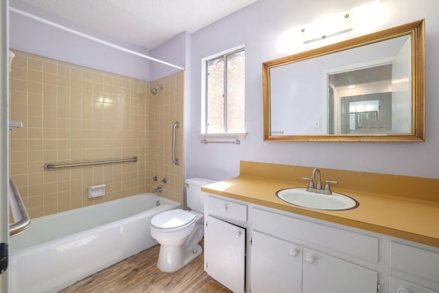 bathroom with toilet, shower / bathtub combination, wood finished floors, a textured ceiling, and vanity