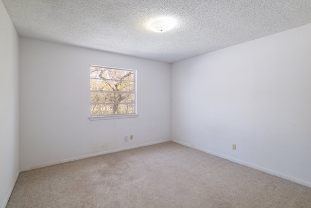 carpeted spare room with baseboards and a textured ceiling