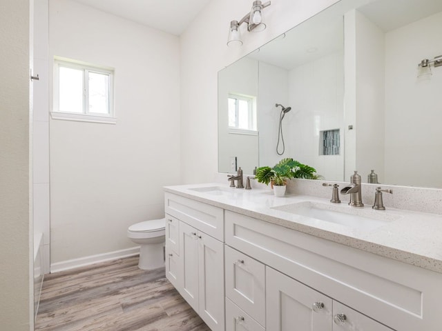 1401 W 7th St, Taylor, TX 76574 - full bath featuring double vanity, healthy amount of natural light, wood finished floors, and washtub / shower combination