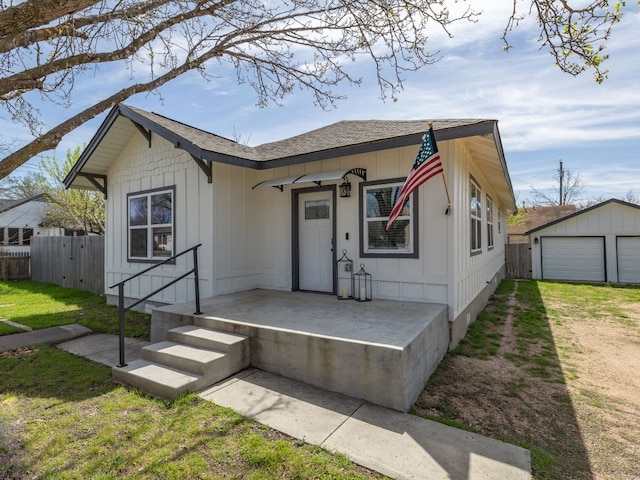 1401 W 7th St, Taylor, TX 76574 - view of front facade featuring an outbuilding, a detached garage, and roof with shingles