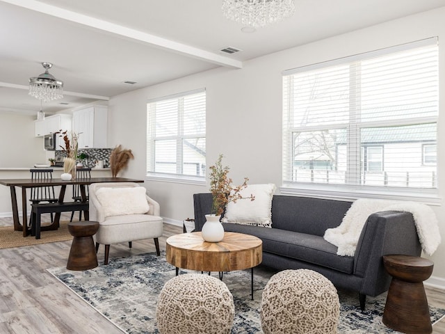 1401 W 7th St, Taylor, TX 76574 - living room with light wood-type flooring, beam ceiling, and a chandelier