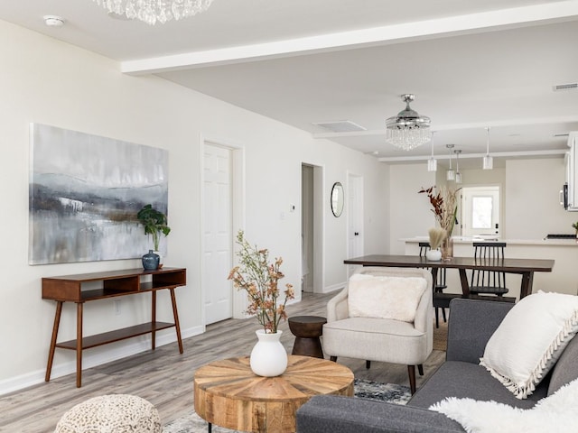 1401 W 7th St, Taylor, TX 76574 - living area with light wood-style flooring, a chandelier, and beamed ceiling