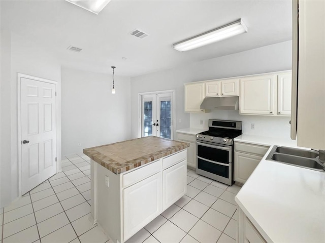 2119 Simbrah Dr, Cedar Park, TX 78613 - kitchen featuring stainless steel stove, under cabinet range hood, a sink, french doors, and a kitchen island