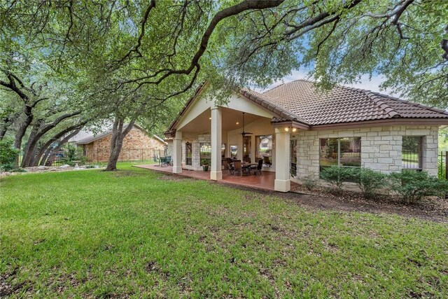 201 Lasso, Horseshoe Bay, TX 78657 - back of property featuring ceiling fan, stone siding, a tile roof, and a lawn