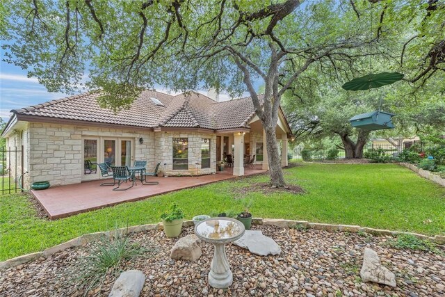 201 Lasso, Horseshoe Bay, TX 78657 - back of property featuring a tiled roof, stone siding, a patio, and french doors