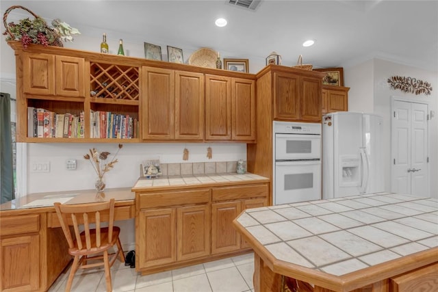 201 Lasso, Horseshoe Bay, TX 78657 - kitchen with white appliances, tile counters, light tile patterned floors, open shelves, and built in desk