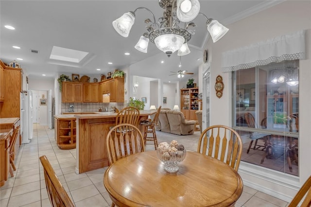 201 Lasso, Horseshoe Bay, TX 78657 - dining space featuring light tile patterned floors, a ceiling fan, crown molding, a skylight, and a chandelier