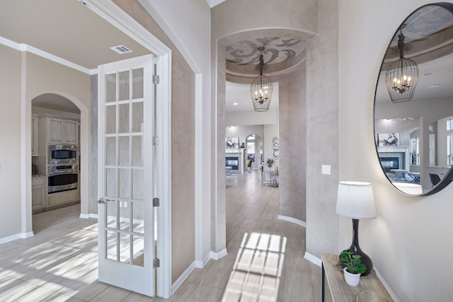 14320 Senia Bnd, Austin, TX 78738 - hall with baseboards, visible vents, arched walkways, and a notable chandelier