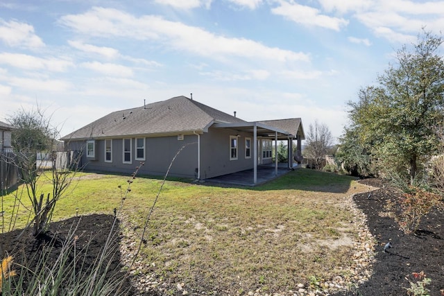14320 Senia Bnd, Austin, TX 78738 - back of property featuring stucco siding, fence, a shingled roof, a patio area, and a lawn