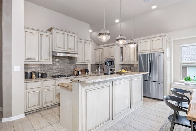 14320 Senia Bnd, Austin, TX 78738 - kitchen featuring a kitchen island with sink, under cabinet range hood, backsplash, pendant lighting, and appliances with stainless steel finishes