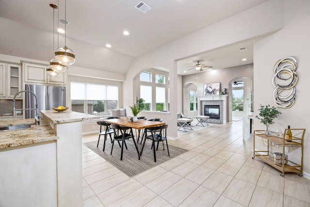 14320 Senia Bnd, Austin, TX 78738 - dining area featuring recessed lighting, a glass covered fireplace, a ceiling fan, visible vents, and arched walkways