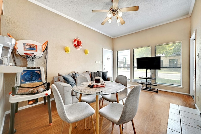 dining area with ornamental molding, a textured ceiling, a ceiling fan, and wood finished floors