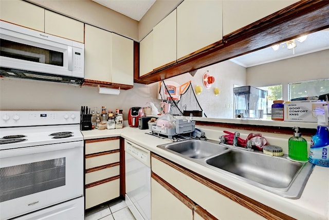 kitchen with white appliances, white cabinets, light countertops, and a sink