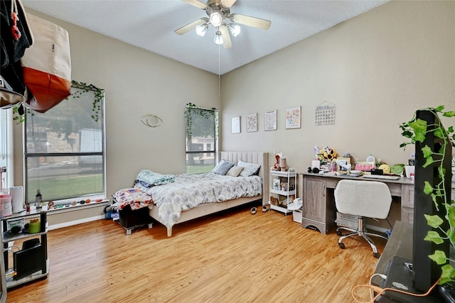 bedroom with baseboards, wood finished floors, and a ceiling fan