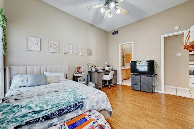 bedroom with visible vents, a ceiling fan, connected bathroom, light wood-style floors, and baseboards