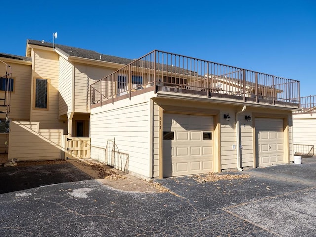 exterior space featuring a balcony, a garage, and driveway