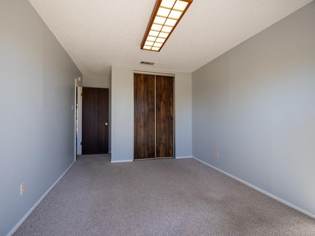 interior space with baseboards, visible vents, and a textured ceiling