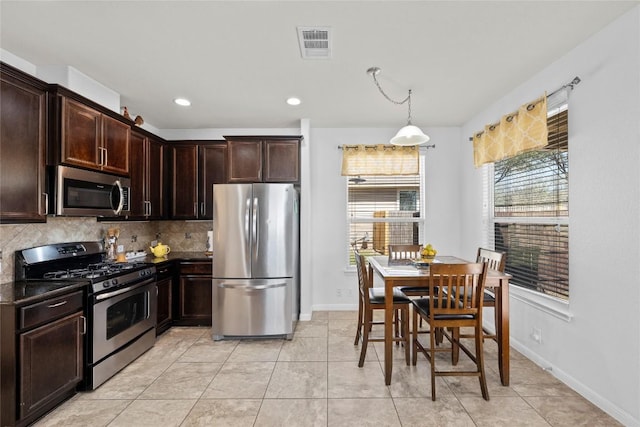 9209 Sweetgum Dr Unit 153, Austin, TX 78748 - kitchen with stainless steel appliances, dark countertops, decorative backsplash, dark brown cabinetry, and baseboards