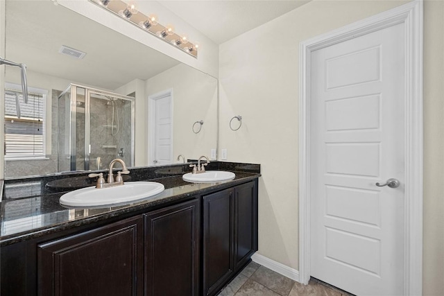 9209 Sweetgum Dr Unit 153, Austin, TX 78748 - full bathroom featuring a stall shower, double vanity, tile patterned flooring, and baseboards