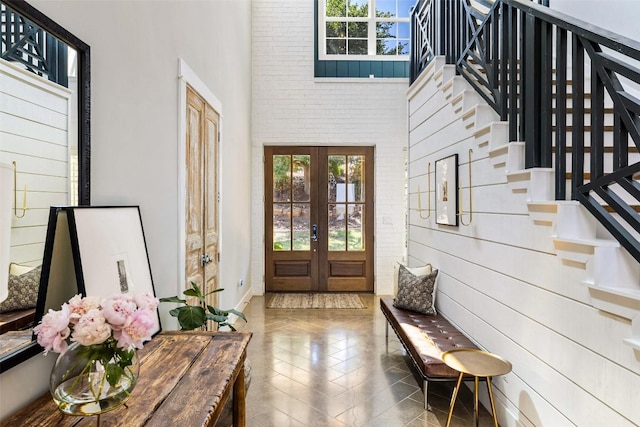 entrance foyer with plenty of natural light, french doors, stairs, and a high ceiling