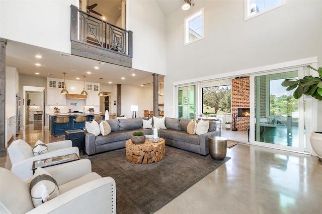 living room with a wealth of natural light, visible vents, concrete flooring, and ornate columns