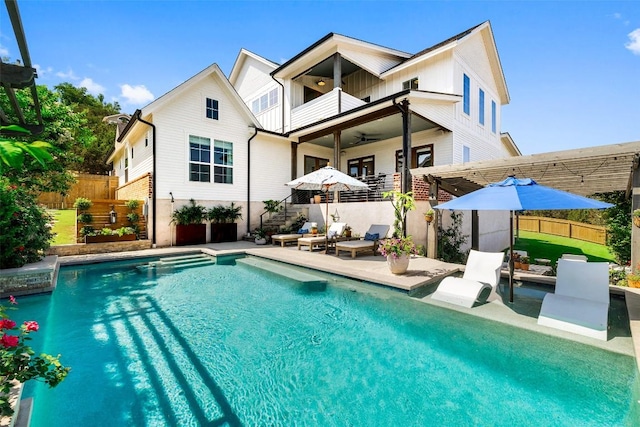 rear view of house with a fenced in pool, ceiling fan, fence, a balcony, and a patio