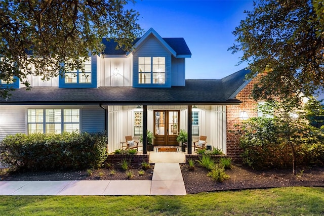 view of front of property featuring a porch, french doors, board and batten siding, and a shingled roof