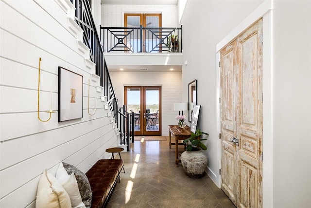 entrance foyer featuring french doors, a towering ceiling, and stairway