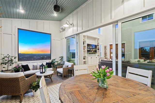 dining area with a high ceiling and a decorative wall