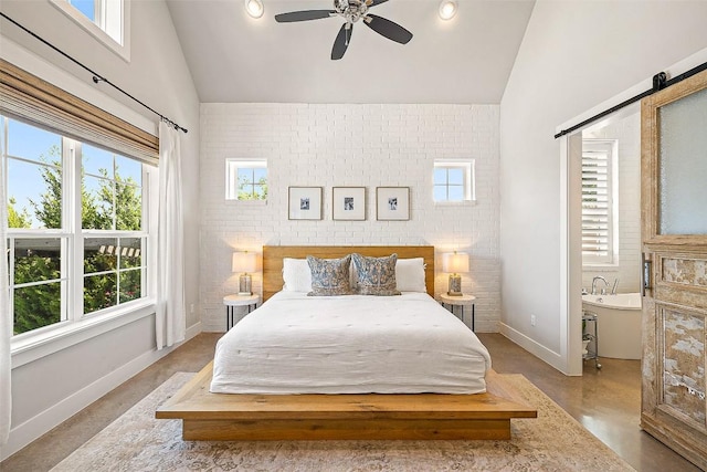 bedroom with finished concrete flooring, a barn door, brick wall, baseboards, and vaulted ceiling